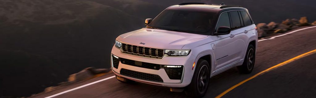 White Jeep Grand Cherokee SUV on mountain road
